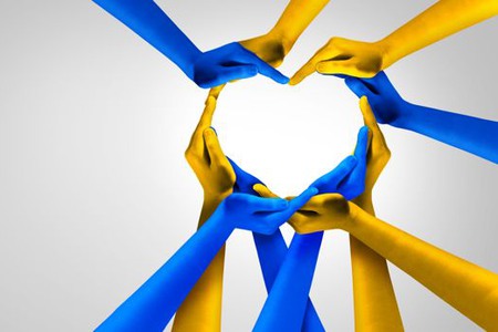 Bilden symboliserar solidaritet med Ukraina; blå- och gulfärgade händer formar ett hjärta