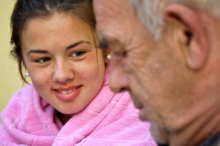 En ung tjej tittar vänligt på sin morfar