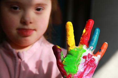 Down syndrome girl with painted hands